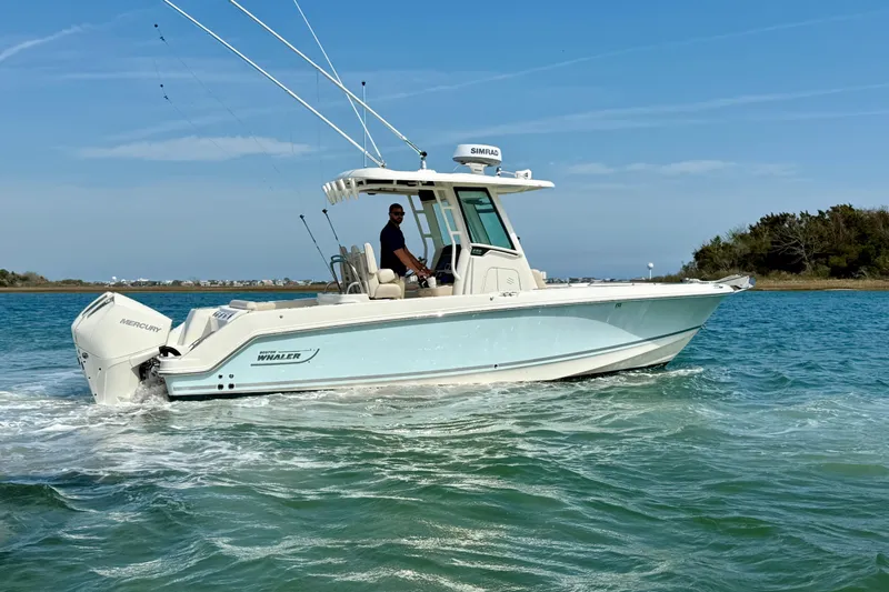  Yacht Photos Pics 2024 Boston Whaler 250 Outrage boat cruising on clear blue water.