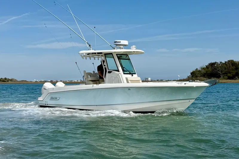  Yacht Photos Pics 2024 Boston Whaler 250 Outrage boat cruising on clear blue water.