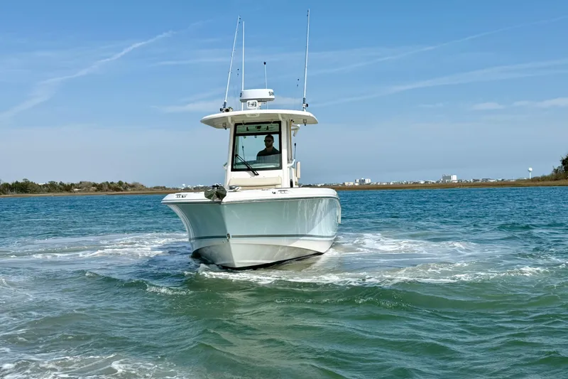  Yacht Photos Pics 2024 Boston Whaler 250 Outrage boat cruising on clear blue water.