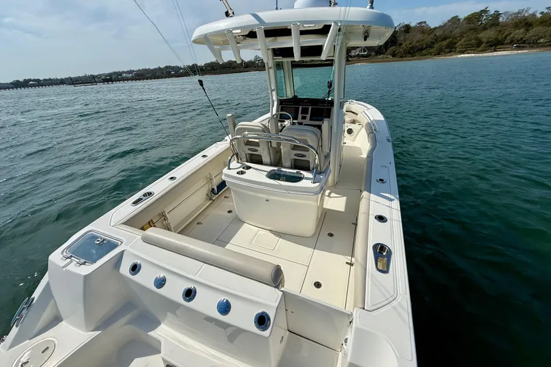  Yacht Photos Pics 2024 Boston Whaler 250 Outrage boat on calm water, showcasing spacious deck and seating.