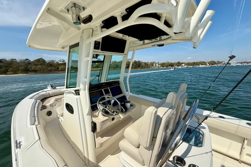  Yacht Photos Pics 2024 Boston Whaler 250 Outrage boat interior with helm, seats, and ocean view.