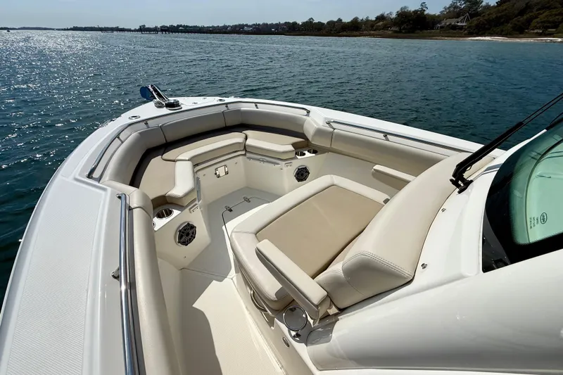  Yacht Photos Pics 2024 Boston Whaler 250 Outrage boat interior with cushioned seating on the water.