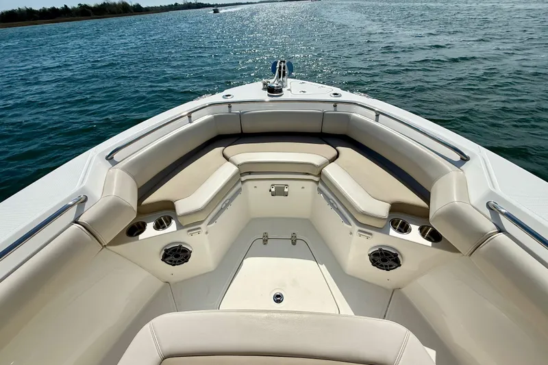  Yacht Photos Pics 2024 Boston Whaler 250 Outrage boat interior with cushioned seating and cup holders on the water.