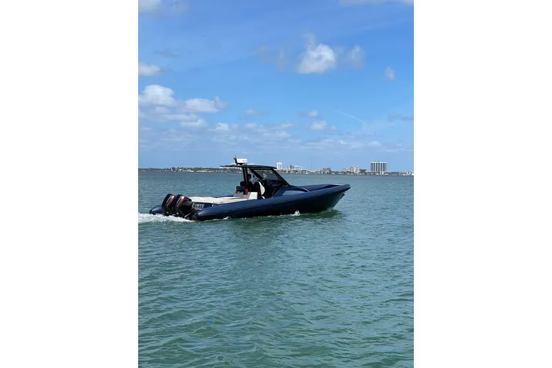  Yacht Photos Pics 2024 Skipper 42 boat cruising on a sunny day with city skyline in background.