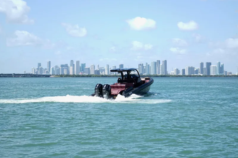  Yacht Photos Pics 2024 Skipper 42 boat cruising on water with city skyline in background.