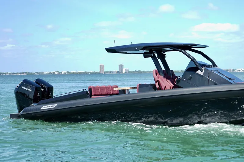  Yacht Photos Pics 2024 Skipper 42 boat cruising on clear blue water with city skyline in background.