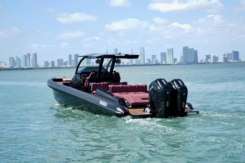  Yacht Photos Pics 2024 Skipper 42 boat cruising near city skyline, featuring dual outboard engines.