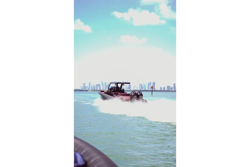  Yacht Photos Pics 2024 Skipper 42 boat cruising on water with city skyline in background.