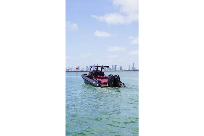  Yacht Photos Pics 2024 Skipper 42 boat cruising on open water with city skyline in background.