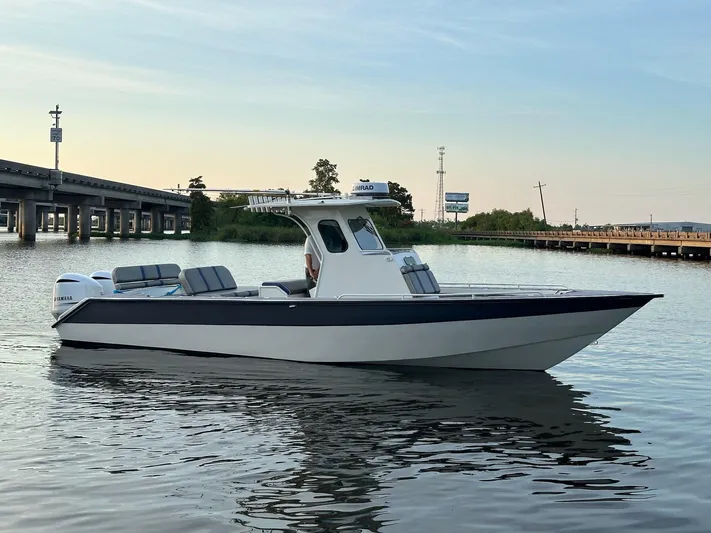 Yacht Photos Pics 2003 Custom Leblanc CC boat on calm water near a bridge at sunset.