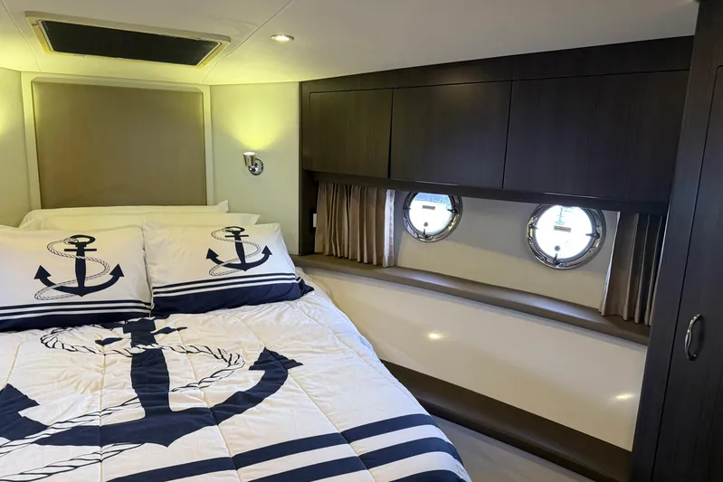 Long Gone Yacht Photos Pics Luxurious 2013 Carver C34 yacht bedroom with nautical-themed bedding and porthole windows.