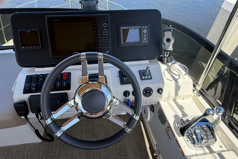 Long Gone Yacht Photos Pics Helm of 2013 Carver C34 yacht with steering wheel and navigation controls.