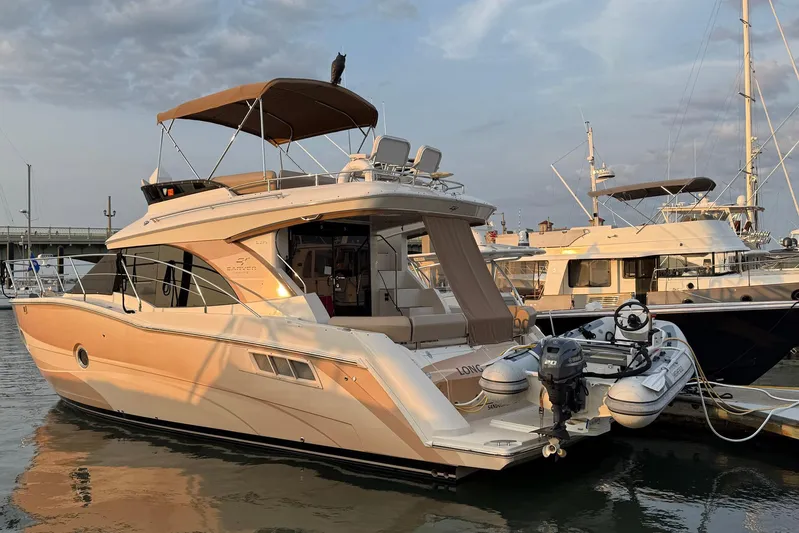 Long Gone Yacht Photos Pics 2013 Carver C34 yacht docked with inflatable boat attached, under a cloudy sky.