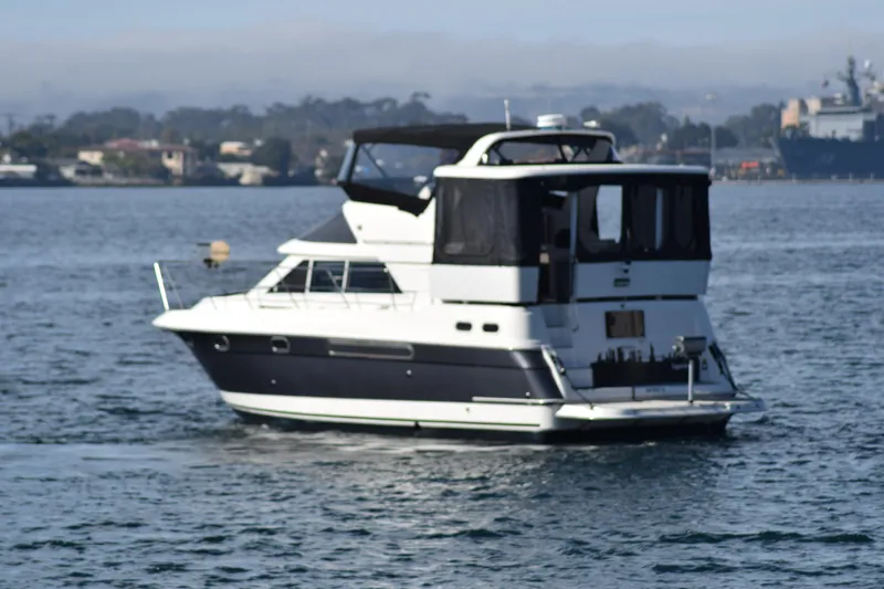 Low Engine Hours Yacht Photos Pics 1995 Cruisers Yachts 3650 ACMY on calm water, featuring sleek design and spacious deck.