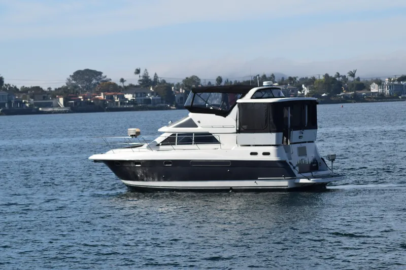 Low Engine Hours Yacht Photos Pics 1995 Cruisers Yachts 3650 ACMY on calm water, coastal background.