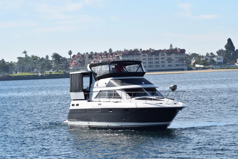 Low Engine Hours Yacht Photos Pics 1995 Cruisers Yachts 3650 ACMY on calm water near coastal buildings.