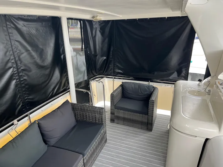 Low Engine Hours Yacht Photos Pics 1995 Cruisers Yachts 3650 ACMY interior with wicker seating and covered deck area.