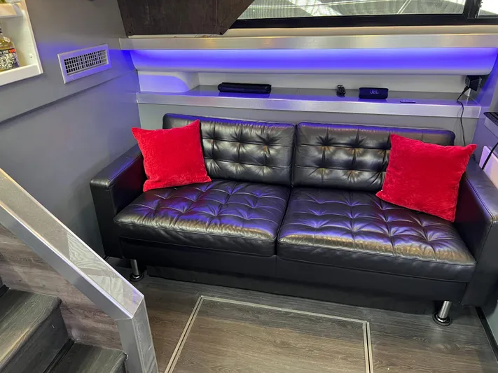 Low Engine Hours Yacht Photos Pics Luxurious 1995 Cruisers Yachts 3650 ACMY interior with black leather sofa and red cushions.