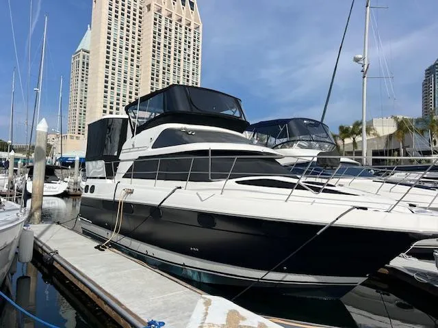 Low Engine Hours Yacht Photos Pics 1995 Cruisers Yachts 3650 ACMY docked at marina with cityscape background.