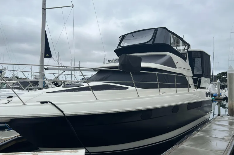 Low Engine Hours Yacht Photos Pics 1995 Cruisers Yachts 3650 ACMY docked, featuring sleek design and spacious upper deck.