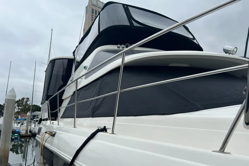 Low Engine Hours Yacht Photos Pics 1995 Cruisers Yachts 3650 ACMY docked, featuring sleek design and black canvas covers.