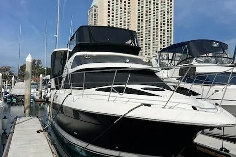 Low Engine Hours Yacht Photos Pics 1995 Cruisers Yachts 3650 ACMY docked at marina with skyscraper backdrop.