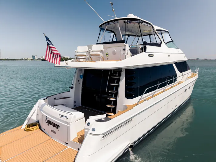 Spencer Yacht Photos Pics 2003 Carver Voyager yacht on water, American flag, sunny day, luxury boat.