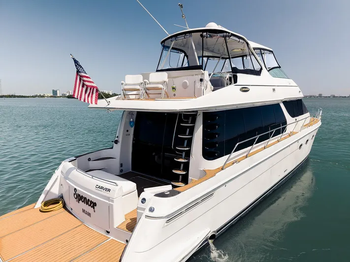 Spencer Yacht Photos Pics 2003 Carver Voyager yacht on water, American flag, sunny day, luxury vessel.
