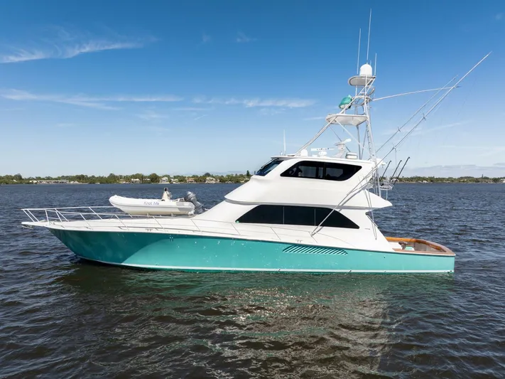 Berry Blessed Yacht Photos Pics 2005 Viking 74' Enclosed Bridge yacht on water, turquoise hull, clear sky background.