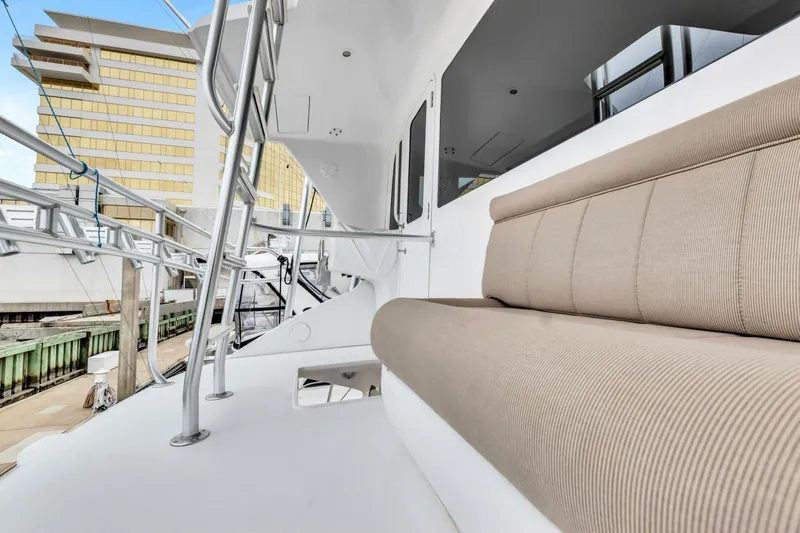 Berry Blessed Yacht Photos Pics 2005 Viking 74' Enclosed Bridge yacht with beige seating, docked near modern buildings.