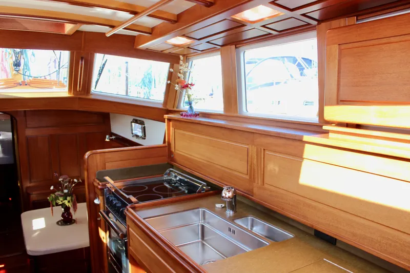 Robert Lewis Yacht Photos Pics Luxurious wooden interior of 2018 Cape George 45 yacht kitchen with stove and sink.