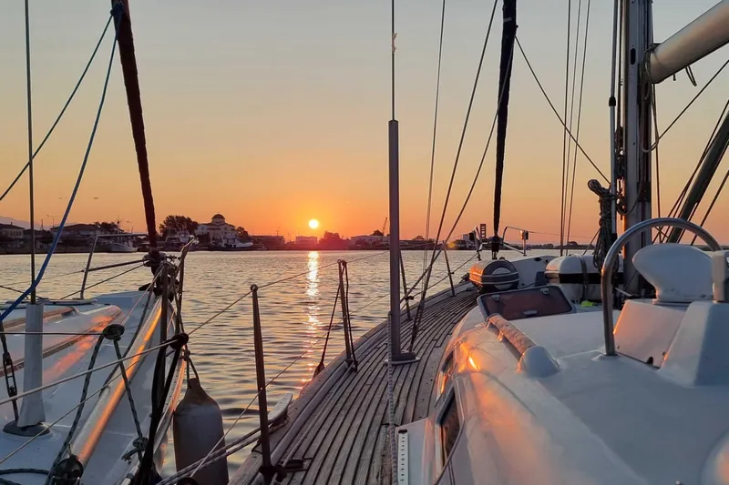 Pac Man Yacht Photos Pics Beneteau Oceanis Clipper 473 sailing at sunset, 2001 model, serene waterfront view.