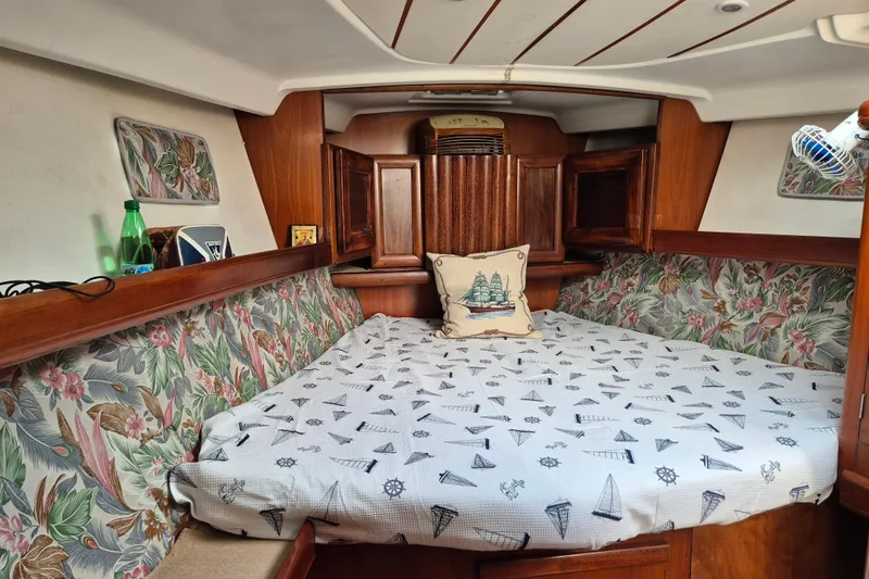 Pac Man Yacht Photos Pics Cozy cabin interior of 2001 Beneteau Oceanis Clipper 473 with nautical-themed bedding.
