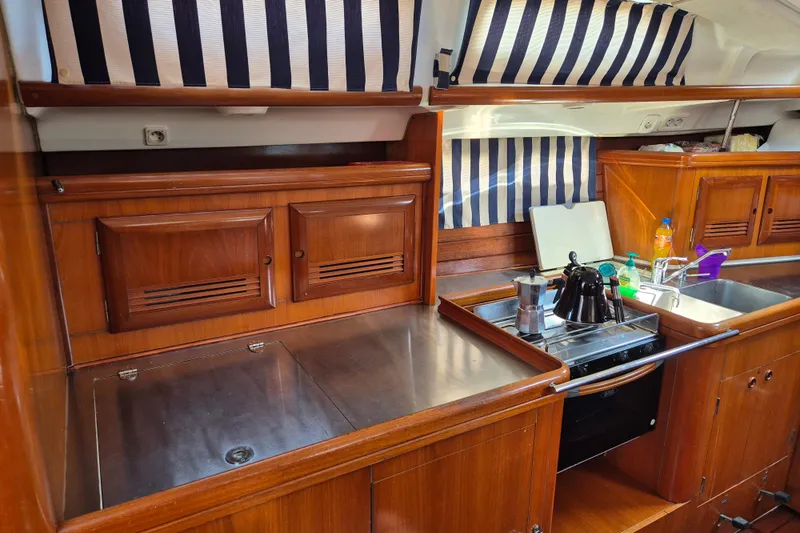 Pac Man Yacht Photos Pics Interior of 2001 Beneteau Oceanis Clipper 473 yacht kitchen with wooden cabinets and appliances.