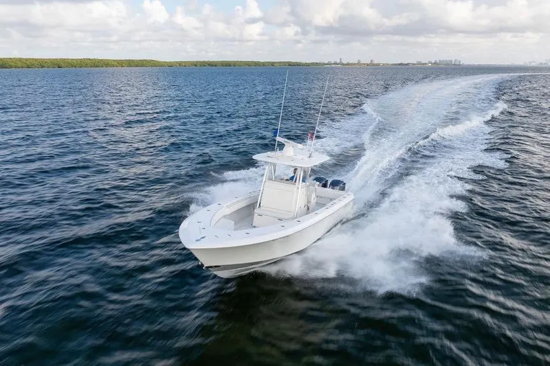  Yacht Photos Pics 2013 Contender 32 ST boat cruising on open water under a cloudy sky.