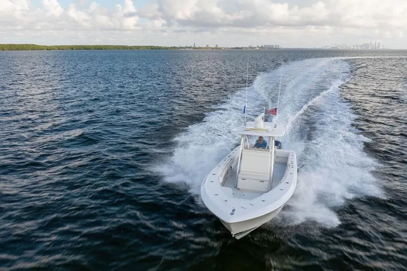  Yacht Photos Pics 2013 Contender 32 ST boat cruising on open water under cloudy sky.