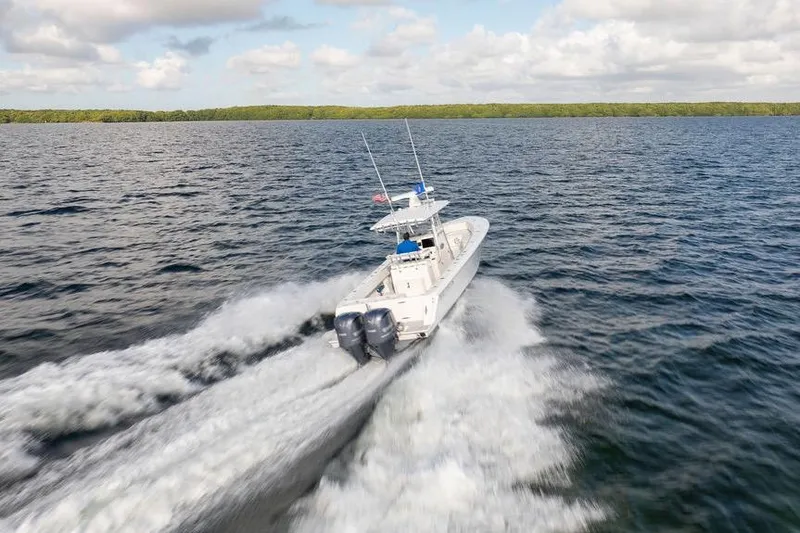  Yacht Photos Pics 2013 Contender 32 ST boat speeding on open water under a cloudy sky.
