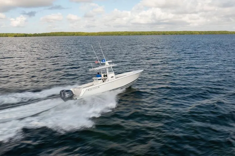  Yacht Photos Pics 2013 Contender 32 ST boat speeding on open water under a cloudy sky.