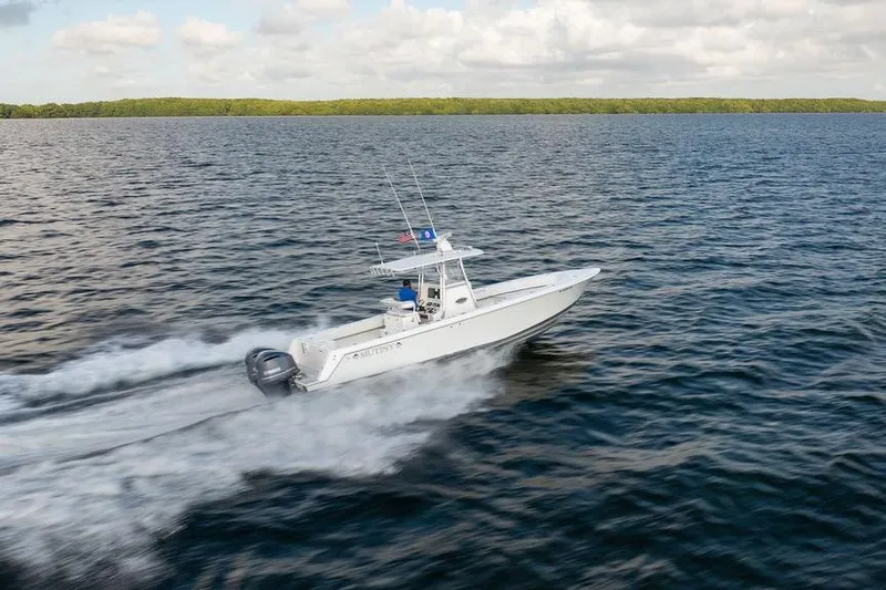  Yacht Photos Pics 2013 Contender 32 ST boat speeding on open water under cloudy sky.