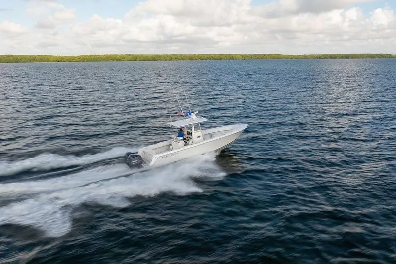  Yacht Photos Pics 2013 Contender 32 ST boat speeding on open water under a cloudy sky.