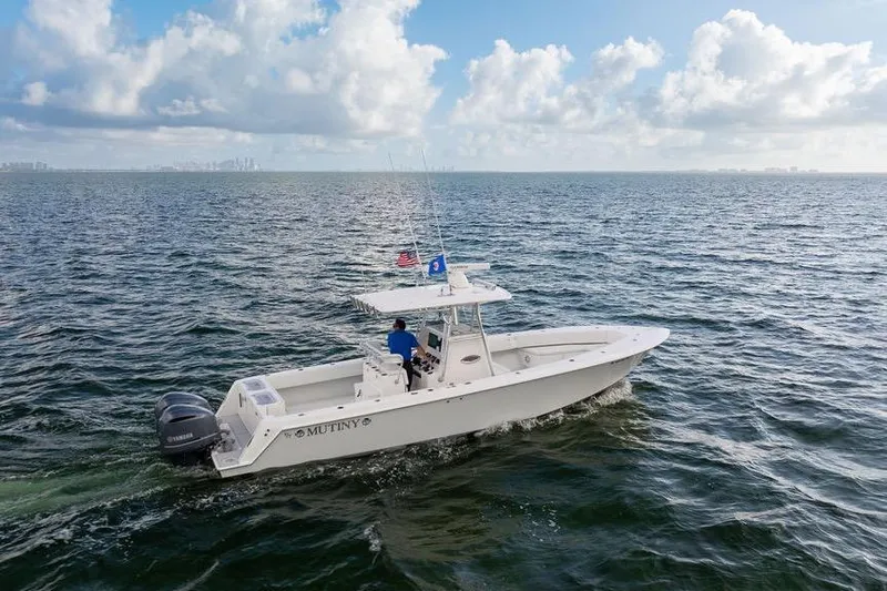 Yacht Photos Pics 2013 Contender 32 ST boat cruising on open water under a partly cloudy sky.