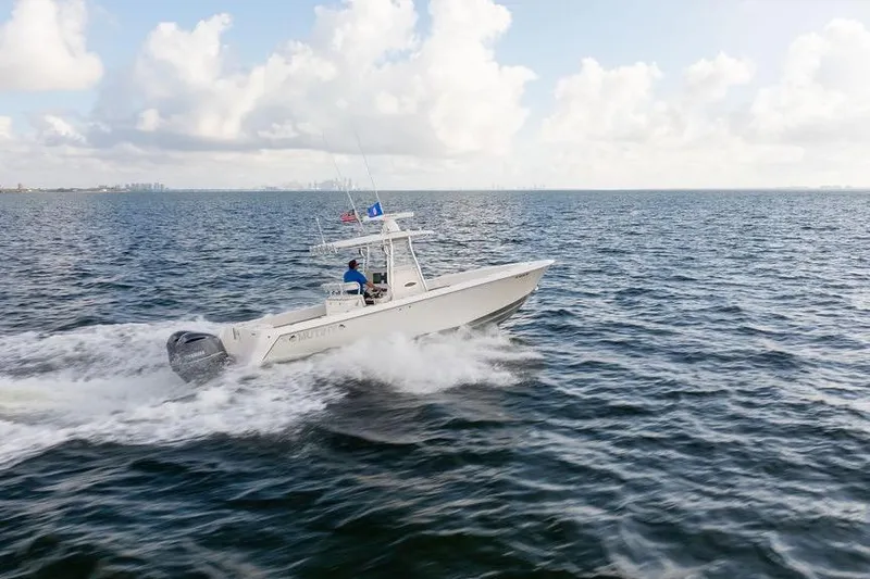  Yacht Photos Pics 2013 Contender 32 ST boat cruising on open water under a cloudy sky.