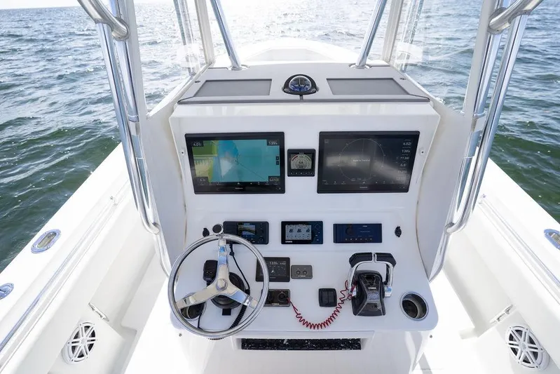  Yacht Photos Pics 2013 Contender 32 ST boat console with navigation screens and steering wheel on open water.