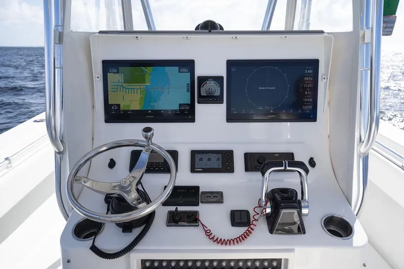  Yacht Photos Pics Control panel of 2013 Contender 32 ST boat with navigation screens and steering wheel.