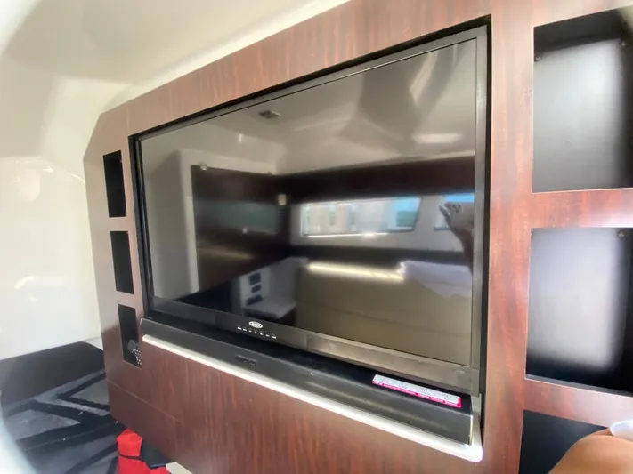 Yacht Photos Pics Flat-screen TV in 2018 Monterey 385 SE yacht interior, surrounded by wooden cabinetry.
