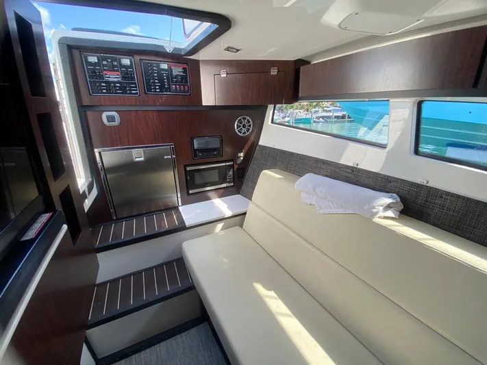  Yacht Photos Pics Interior of 2018 Monterey 385 SE boat with seating, kitchenette, and control panel.