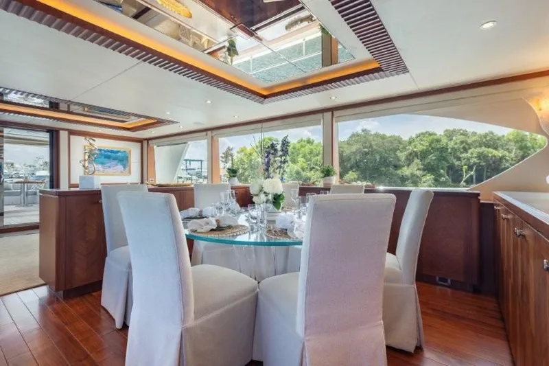 Chindon Yacht Photos Pics Luxurious dining area inside a 2017 Ocean Alexander Motor Yacht, featuring elegant decor and large windows.