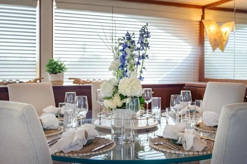 Chindon Yacht Photos Pics Elegant dining setup on 2017 Ocean Alexander Motor Yacht with floral centerpiece.