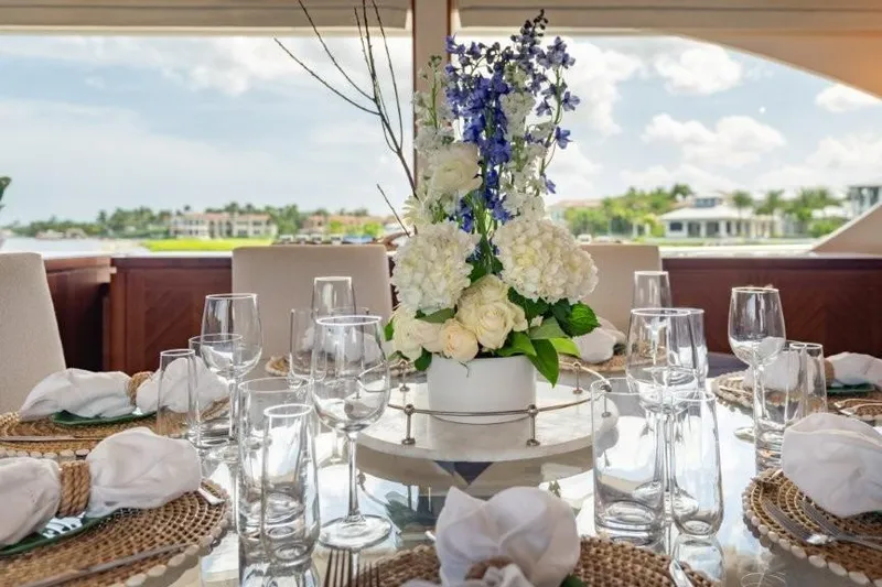 Chindon Yacht Photos Pics Elegant dining setup on 2017 Ocean Alexander Motor Yacht with floral centerpiece.