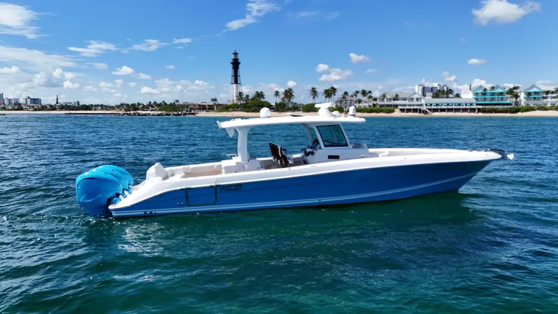  Yacht Photos Pics 2022 HCB Lujo boat on blue ocean with lighthouse and coastal background.
